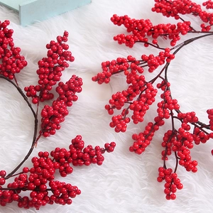 Festive red berry branch wreath decoration on white fur background for Christmas home decor