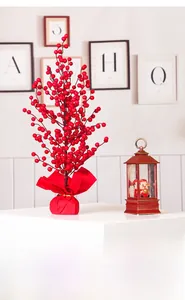 Close-up of artificial red berry branches with festive gold ribbon and red silk base