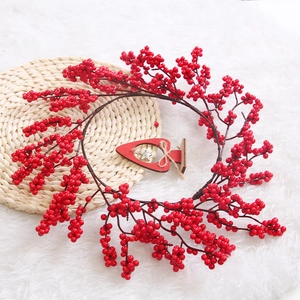 Red berry Christmas wreath ornament on rustic woven mat with cozy white plush background