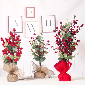 Trois plantes de houx artificielles avec baies rouges et bases en lin et tissu rouge