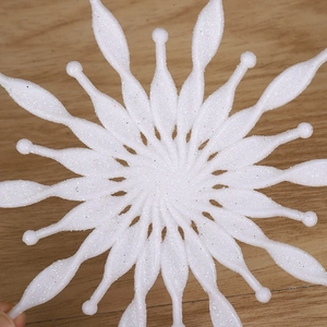 3D white snowflake Christmas ornament with glitter finish on wooden background