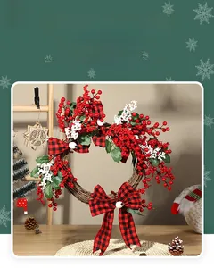Detail of red and white berries Christmas wreath with plaid bows on natural rattan