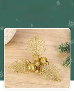 Detail of glittery gold holly branch pick with hollow leaf texture and festive berries