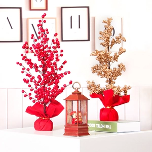 Artificial red and gold berry trees with vintage lantern snow globe for festive home decor