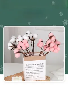 Detailed view of pink and white faux cotton stems in a Nordic style paper bag decor