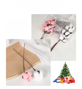 Close-up of artificial pink and white cotton flower stems with natural wooden branches