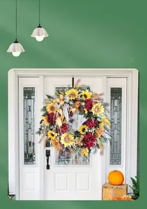 Detail of French country sunflower wreath with red peonies and striped ribbon on door