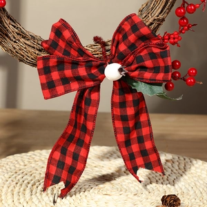 Artificial Christmas wreath with red buffalo plaid bow and red berries on a rustic vine ring