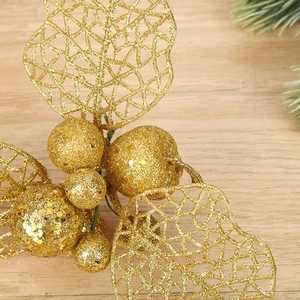 Glittering gold hollowed Christmas flower pick with sequins on a wooden background
