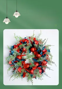Macro detail of Nordic Christmas wreath with pine needles, red baubles and ribbons
