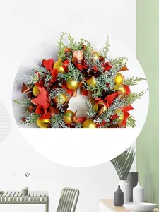 Detail of Nordic Christmas wreath with green pine branches, red ribbons and gold baubles