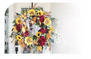Detail of autumn wreath with sunflowers, red peonies, maple leaves and a plaid bow tie