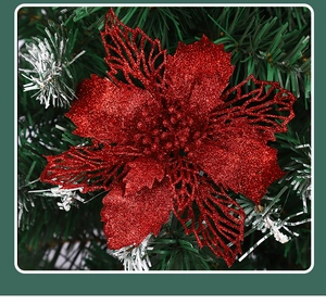 Close-up of red glitter hollow Christmas flower on green pine tree branch decorations