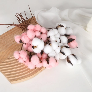 Artificial white and pink cotton flower stems on a wooden tray for home and wedding decor
