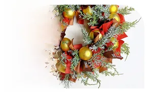 Detailed close-up of Nordic Christmas wreath with pine needles, gold balls and ribbons