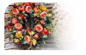 Detailed view of autumn harvest wreath with orange roses, pumpkins, and mixed fall foliage