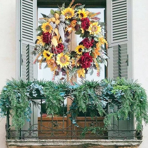 Autumn wreath with sunflowers and red peonies on window for festive decoration