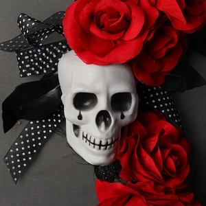 Halloween wreath featuring a realistic white skull and vibrant red silk roses