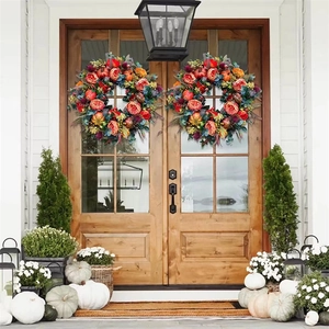 Detail of harvest wreaths with mini pumpkins and berries on a wooden double door