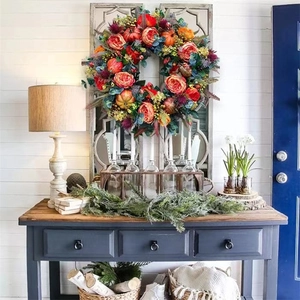 Detail of autumn wreath with orange peonies, pumpkins and berries on a vintage mirror