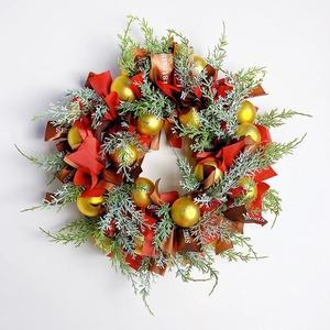 Nordic Christmas wreath with pine needles, red bows, gold balls and festive ribbons