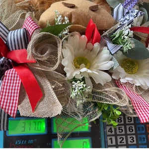 Detail of Easter floral wreath featuring white daisies and colorful ribbons on burlap base