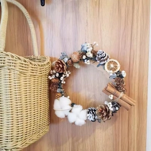 Rustic Christmas wreath with pine cones and cinnamon on a natural rattan base