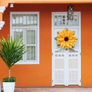 Detail view of sunflower door wreath with vibrant yellow petals on a white door