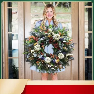 Autumn eucalyptus wreath with white pumpkins and purple flowers hanging on a glass door