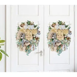 Detail of Highland Cow Easter wreaths with roses and stripes on white double doors