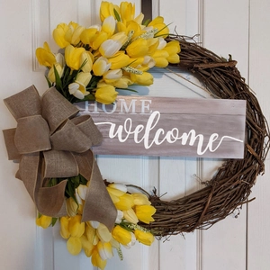 Detail of tulip wreath featuring welcome home wooden sign and rustic burlap bow decor