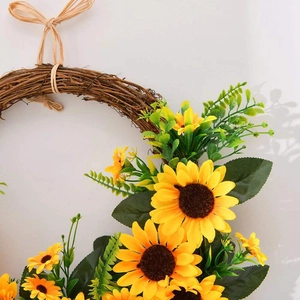 Handcrafted spring sunflower wreath with yellow flowers and green leaves on a vine frame
