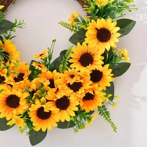 Vibrant artificial sunflower wreath with green leaves on a natural rattan wood base