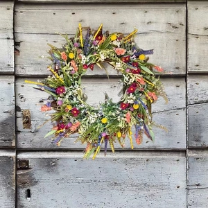 Handcrafted Texas wildflower wreath with vibrant purple and yellow flowers on a rustic wood door