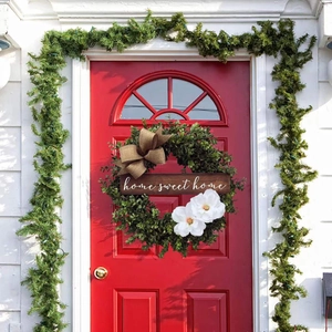 Artificial eucalyptus wreath with home sweet home sign and white flowers on red door