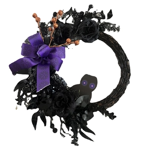 Halloween wreath with black owl, purple bow, and faux roses on a grapevine base