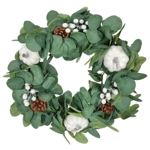 Autumn wreath with eucalyptus leaves, white pumpkins and pinecones for home decor