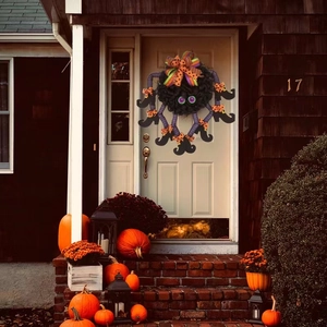 Halloween spider wreath with purple witch legs and striped boots on a rustic white front door