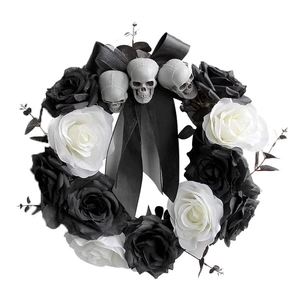 Halloween wreath with black and white roses, skulls, and a large black satin ribbon