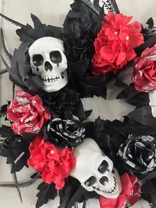 Detail of Halloween wreath with skull and red roses with glitter accents on dark leaves