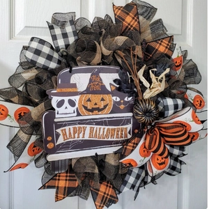 Halloween wreath with pumpkin, skeleton and black cat on a white indoor door