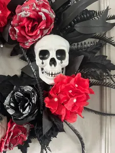 Detail of Halloween wreath with skull, dark red glitter roses and black feathers decoration