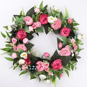 Spring peony wreath with red and pink silk flowers and green leaves on white background