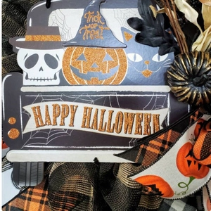 Close-up of Halloween wreath featuring a vintage truck with pumpkin and glitter details
