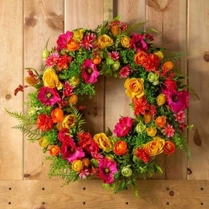 Dettaglio ravvicinato della ghirlanda floreale con rose e margherite su muro di legno