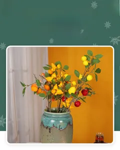 Detailed view of faux lemon and pomegranate branches in a vintage celadon porcelain vase