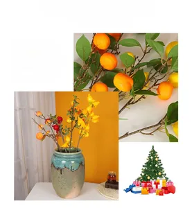 Detailed close-up of vibrant artificial fruit branches with green leaves for home decor