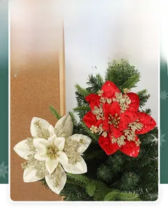 Close-up of red and white artificial Christmas poinsettias with gold glitter and pine needles