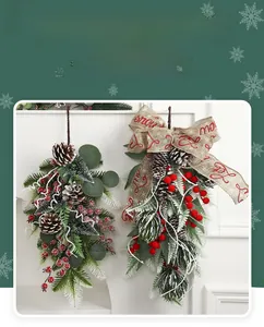Close-up of artificial Christmas hanging teardrop with pine cones, red berries and festive bow