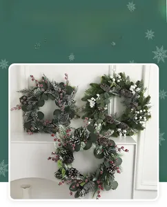 Dettaglio di tre ghirlande natalizie con aghi di pino, bacche di neve e pigne decorative